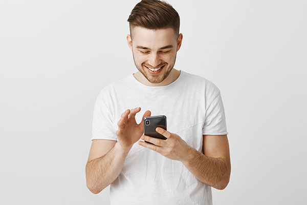 Hombre sonriente visitando página web o aplicación móvil