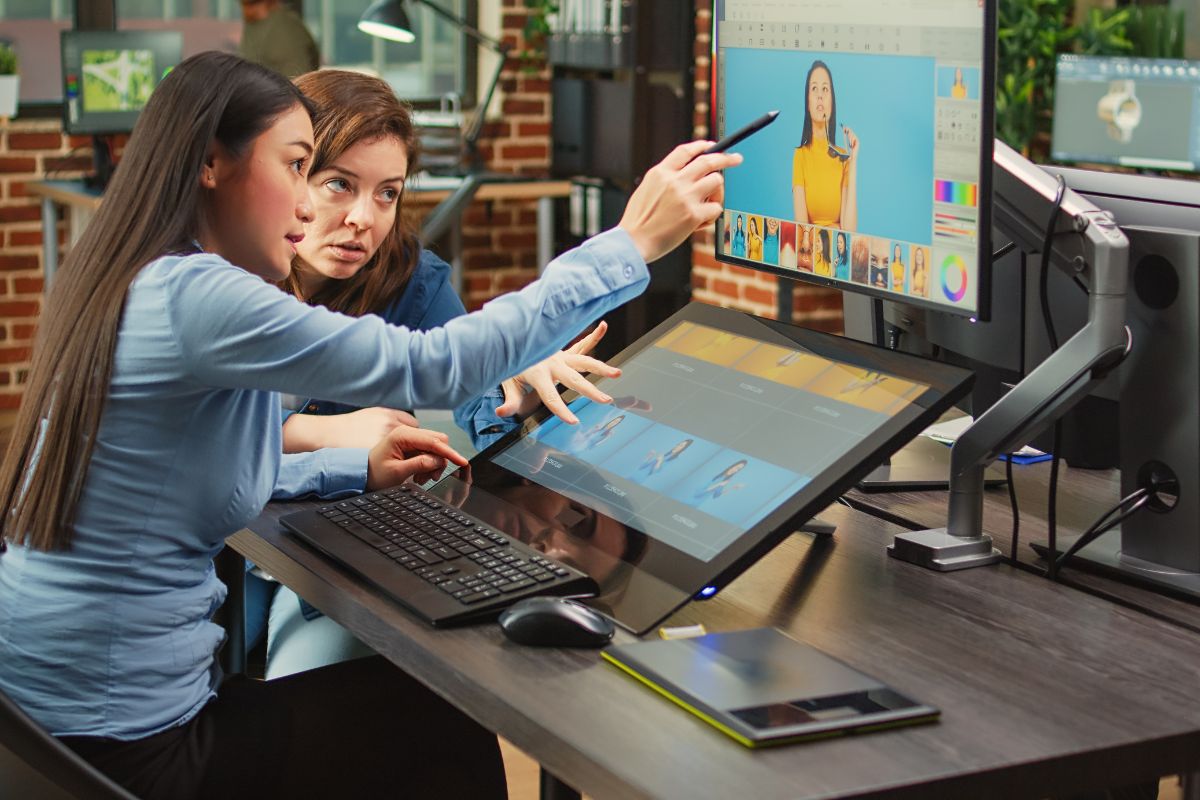 Dos personas revisando el sitio web de su negocio en una computadora portátil, analizando resultados y estadísticas de crecimiento digital.