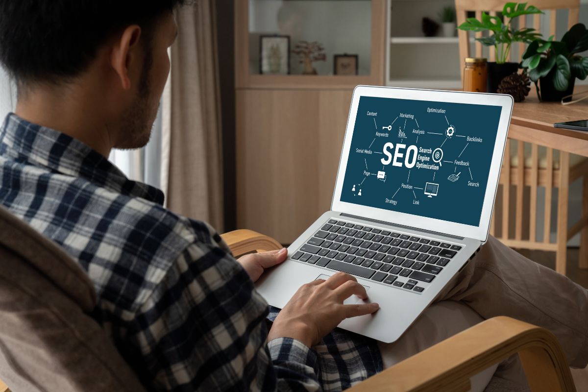 Dos personas revisando el sitio web de su negocio en una computadora portátil, analizando resultados y estadísticas de crecimiento digital.