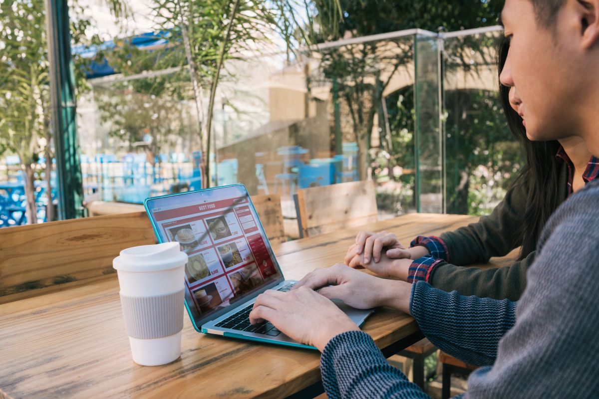 Hombre de negocios mostrando una laptop con el diseño de una página web en construcción, simbolizando la creación de un sitio web profesional.