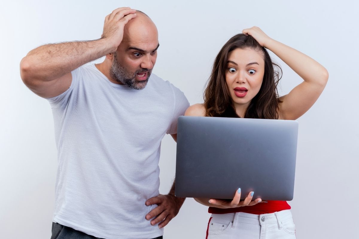 Dos personas revisando el sitio web de su negocio en una computadora portátil, analizando resultados y estadísticas de crecimiento digital.