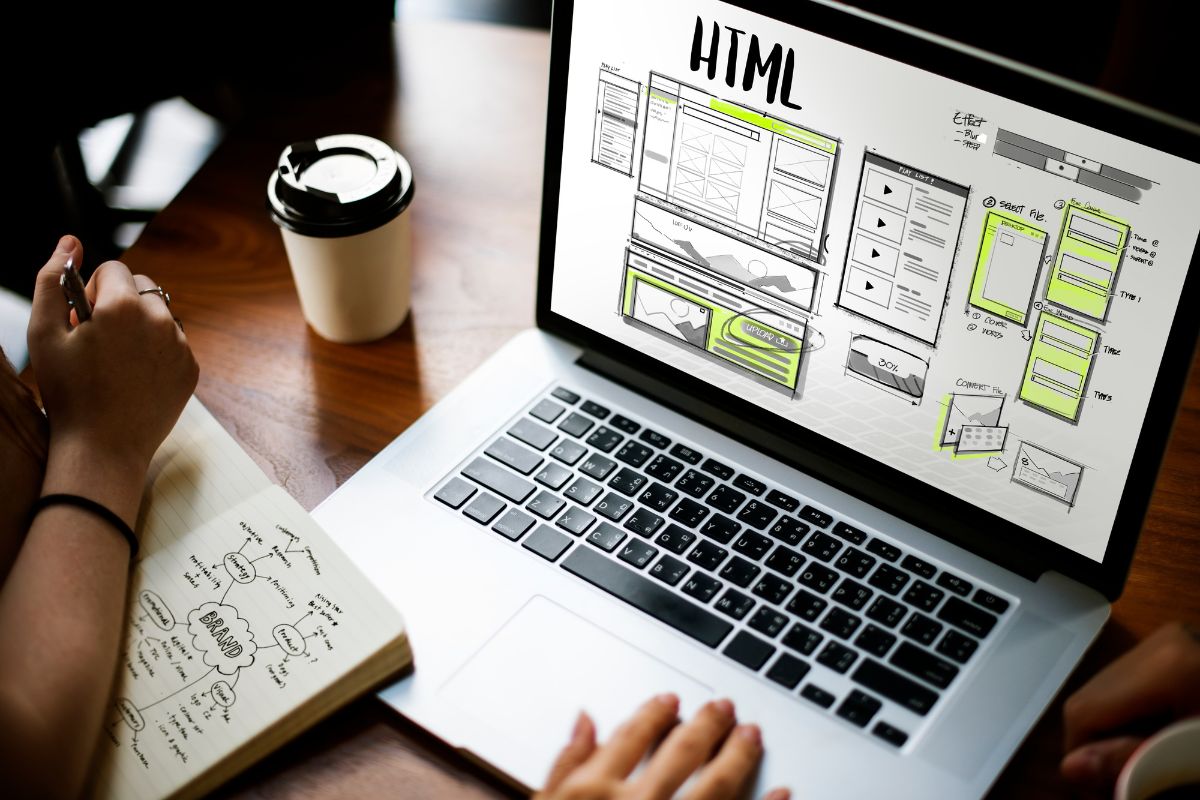 Dos personas revisando el sitio web de su negocio en una computadora portátil, analizando resultados y estadísticas de crecimiento digital.