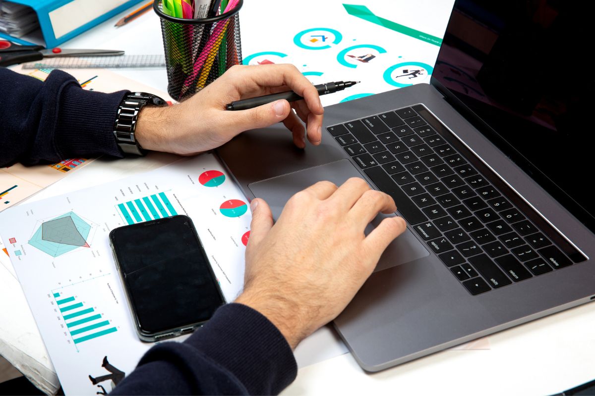 Hombre de negocios mostrando una laptop con el diseño de una página web en construcción, simbolizando la creación de un sitio web profesional.