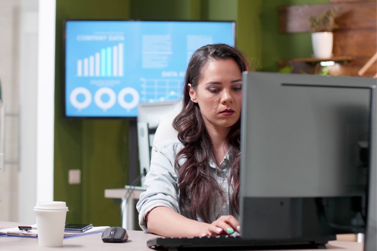 Dos personas revisando el sitio web de su negocio en una computadora portátil, analizando resultados y estadísticas de crecimiento digital.