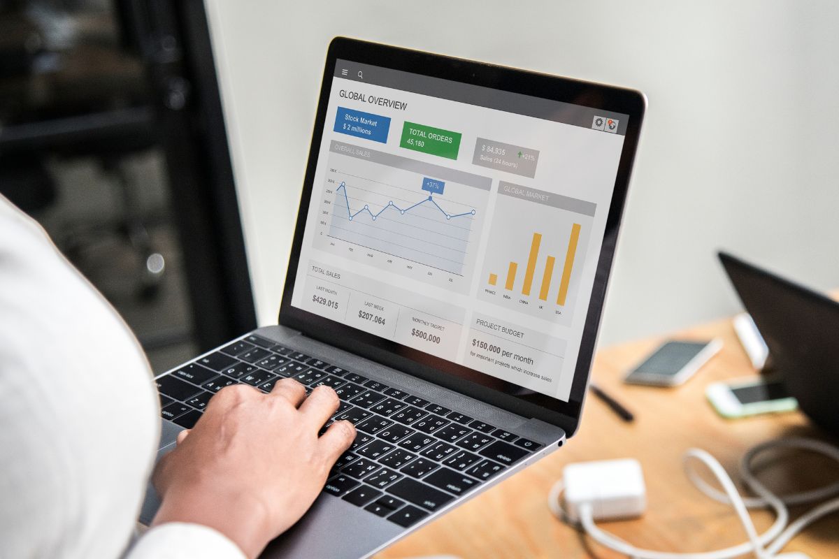 Dos personas revisando el sitio web de su negocio en una computadora portátil, analizando resultados y estadísticas de crecimiento digital.
