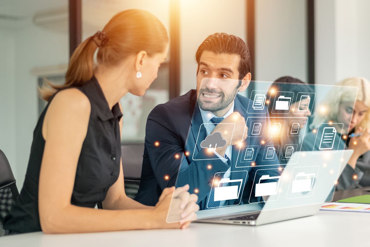 Dos personas revisando el sitio web de su negocio en una computadora portátil, analizando resultados y estadísticas de crecimiento digital.